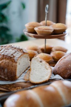 A delightful display of fresh breads and muffins on a rustic wooden table.