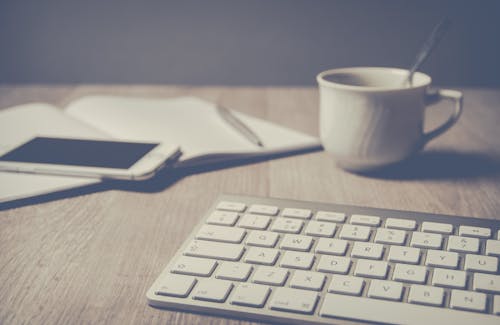 Teclado Mágico Al Lado De La Taza De Café En El Escritorio