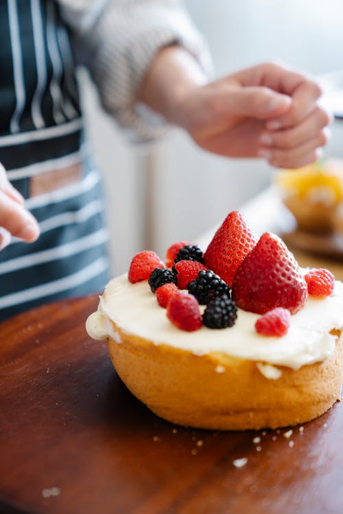 Person Holding a Bread With Strawberry and Cream