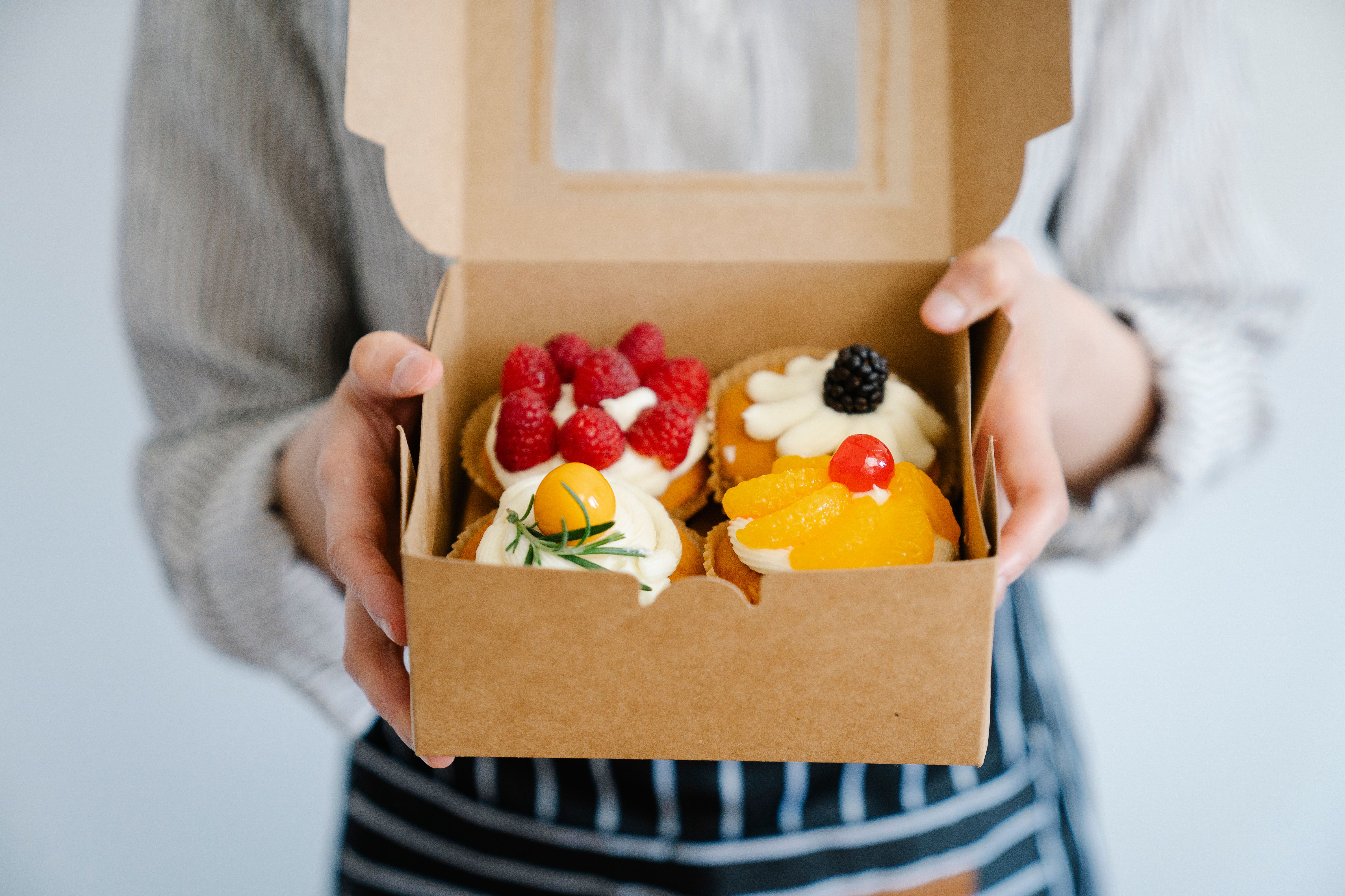 Chef adding ingredients to boxed cake mix batter in a white bowl