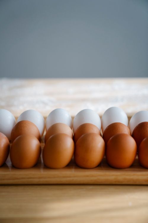 Free Close-up of diverse eggs arranged neatly on a wooden board in a minimalist style Stock Photo