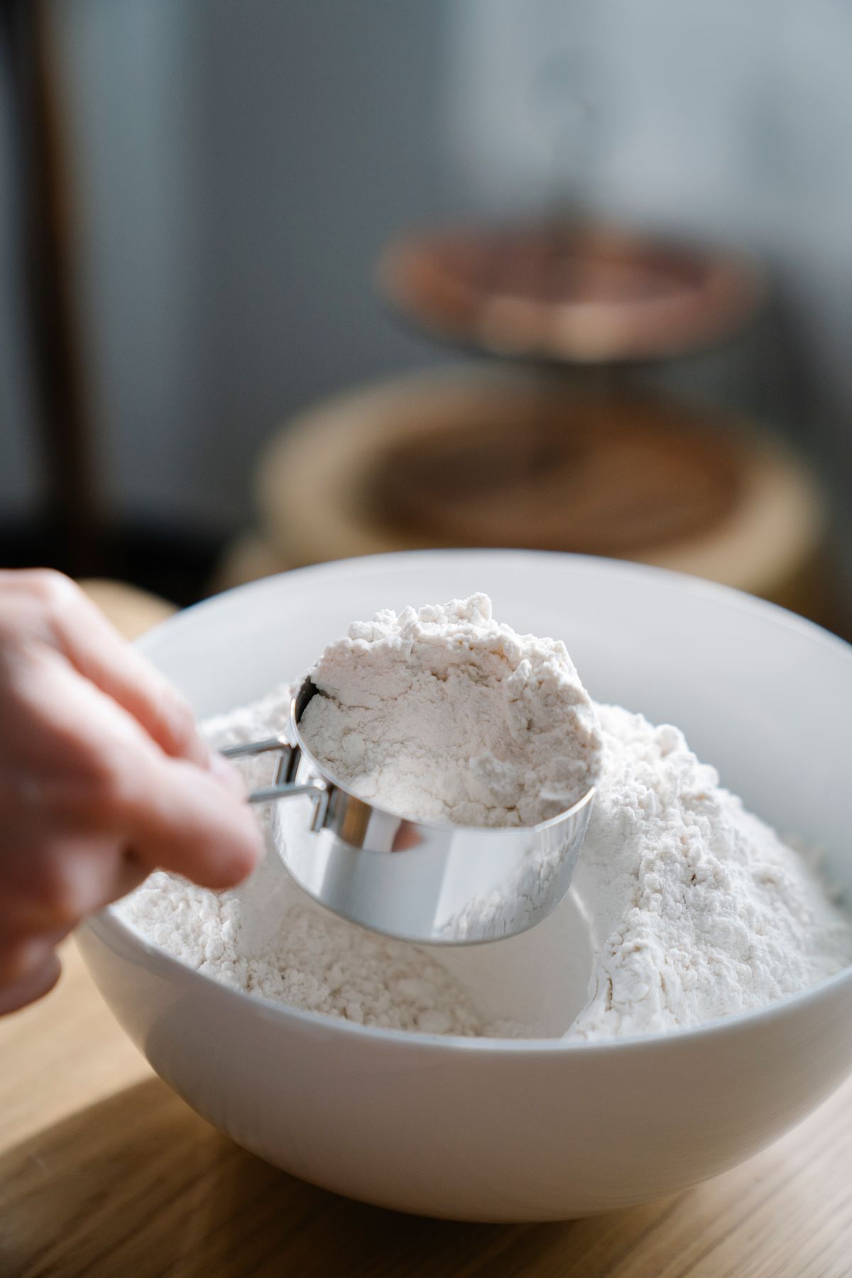Flour being scooped and measured with a measuring cup