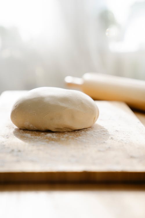 Close Up Photo of Dough on Wooden Board