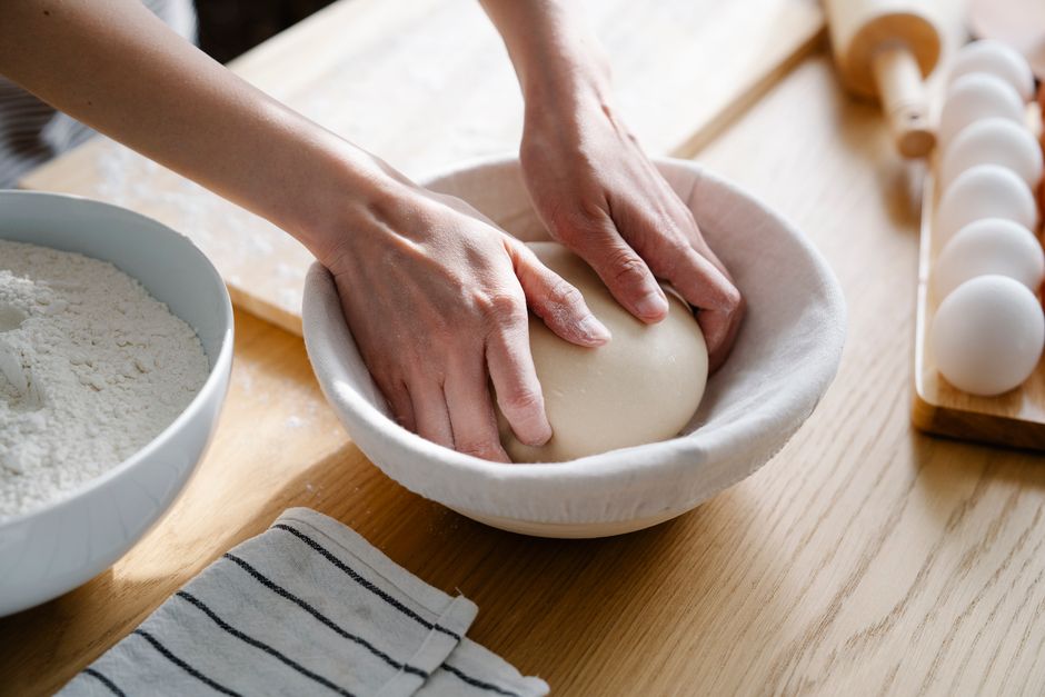 Hands kneading dough with flour and eggs