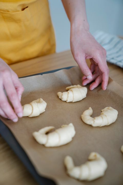 Pastry Chef Career Path in India: Salary, Stages, and How to Start (2026) 2 Close-up of a pastry chef's hands forming croissants on a professional baking tray.