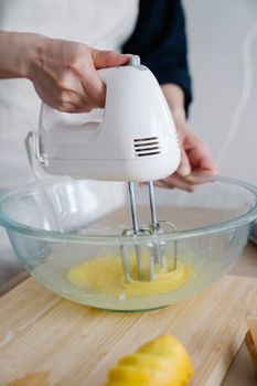 Close-up of mixing ingredients in a glass bowl using a hand mixer for baking.
