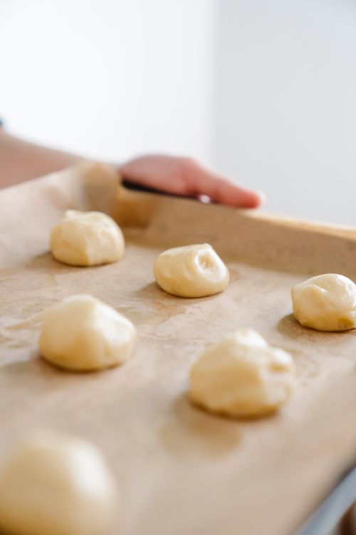 Free Fresh dough balls on a parchment-lined baking sheet for homemade bread. Stock Photo