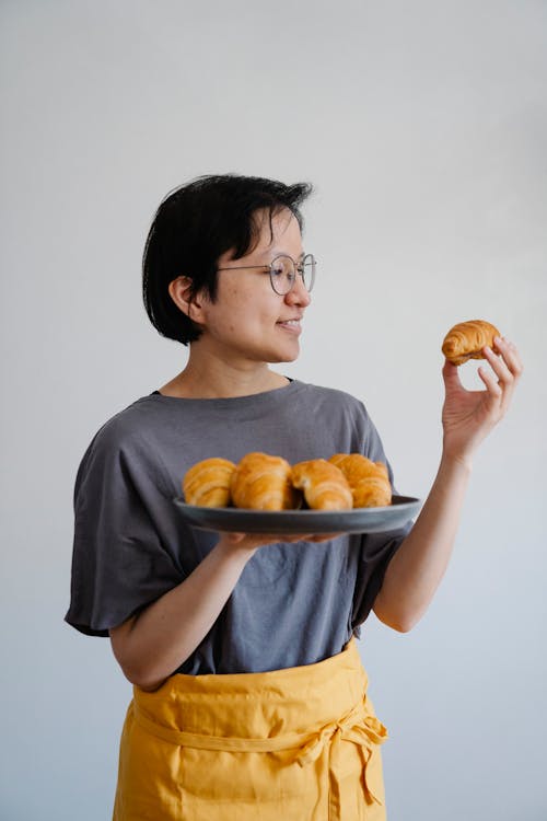 Smiling Woman Holding Cake in Hand