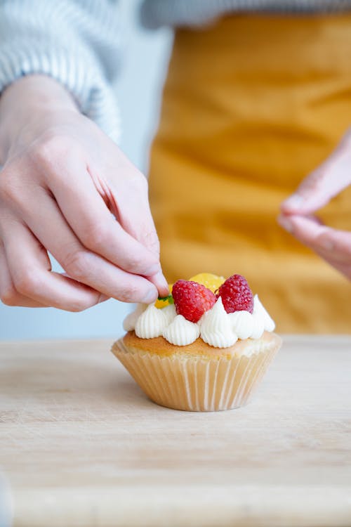 Person Decorating a Cupcake