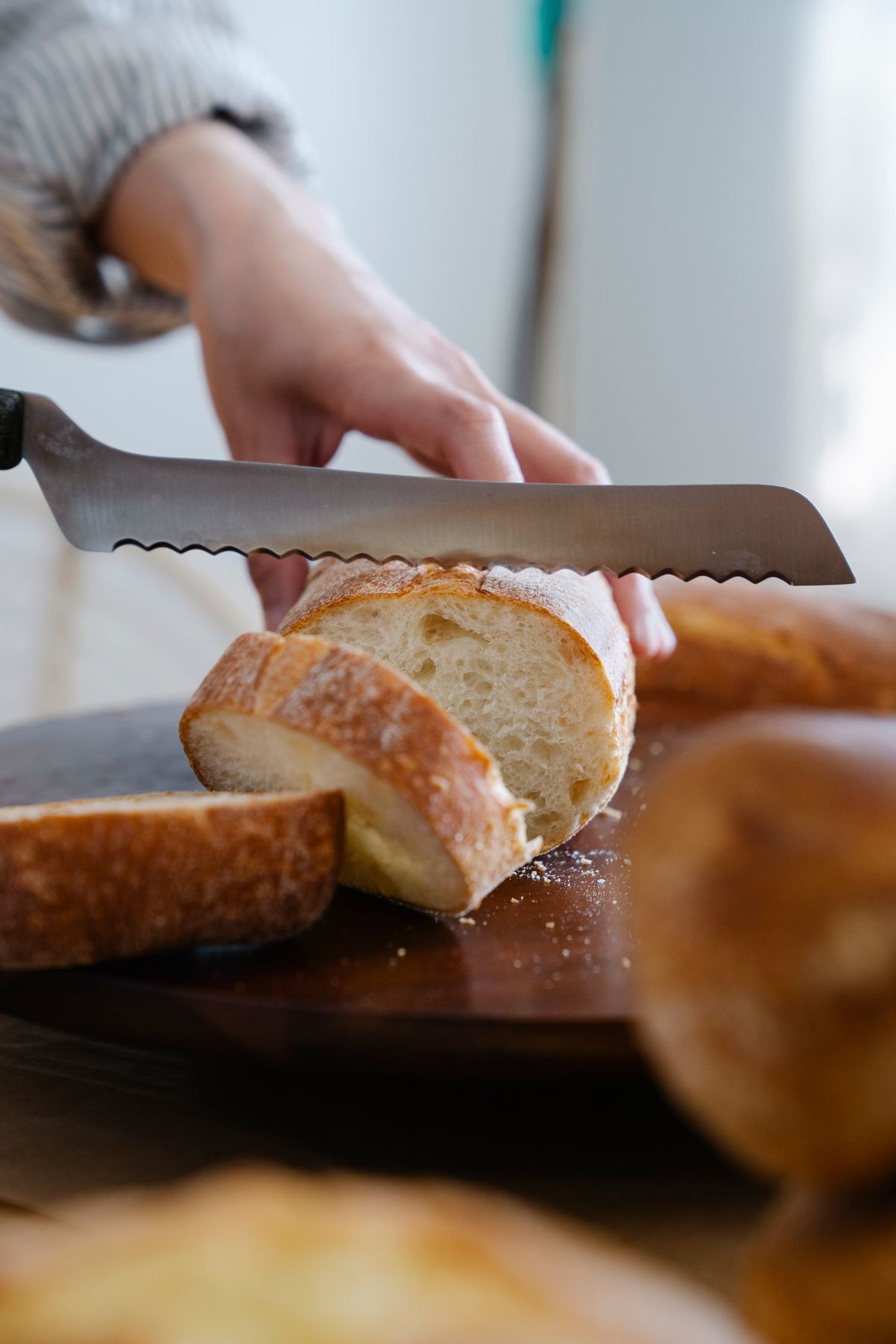 Serrated blades need a different sharpening approach than straight edges Close-up of a serrated knife blade slicing bread