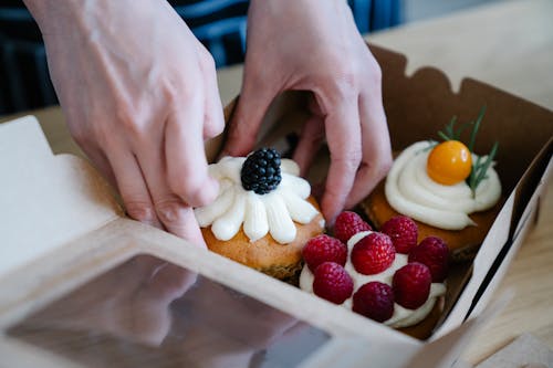 Free Close up of Hands Putting Cupcakes into a Box Stock Photo