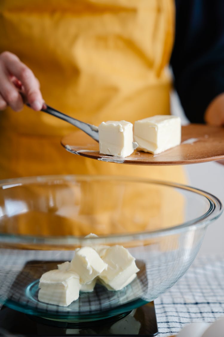 Woman Putting Butter In The Bowl During Baking 