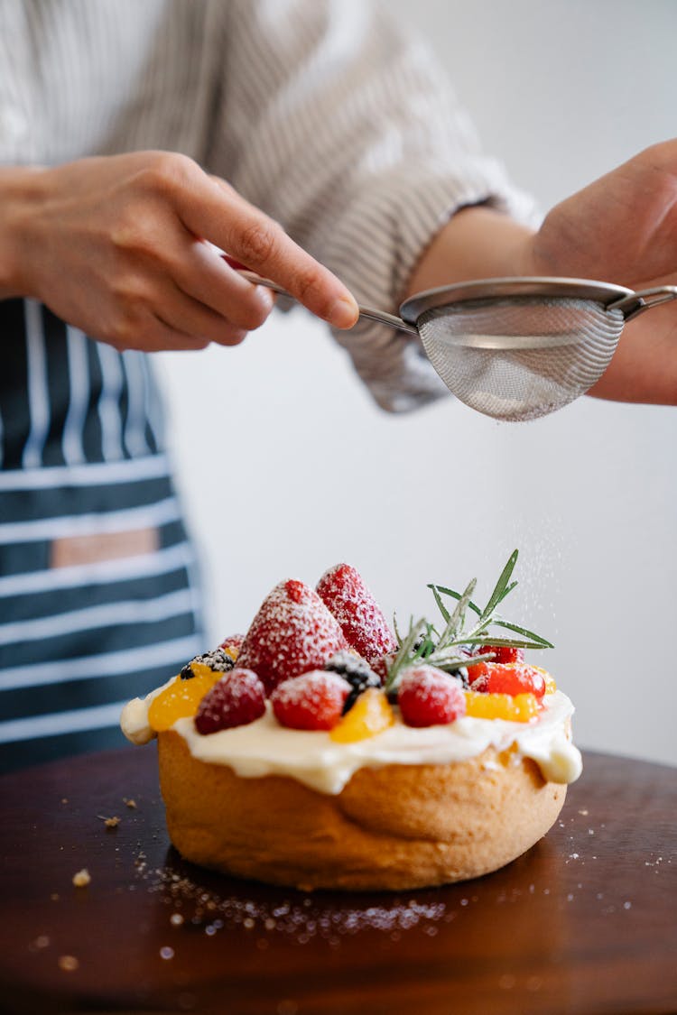 Close-up Of Person Decorating Cake