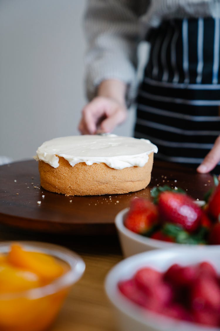 Woman Putting Icing On A Cake 