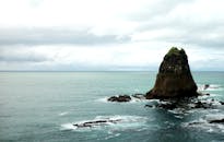 印度尼西亚乌卢汉的岩石岛屿和海浪在多云天空下呈现出令人惊叹的景色