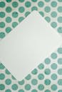 White Square Paper on Green and White Polka Dot Textile