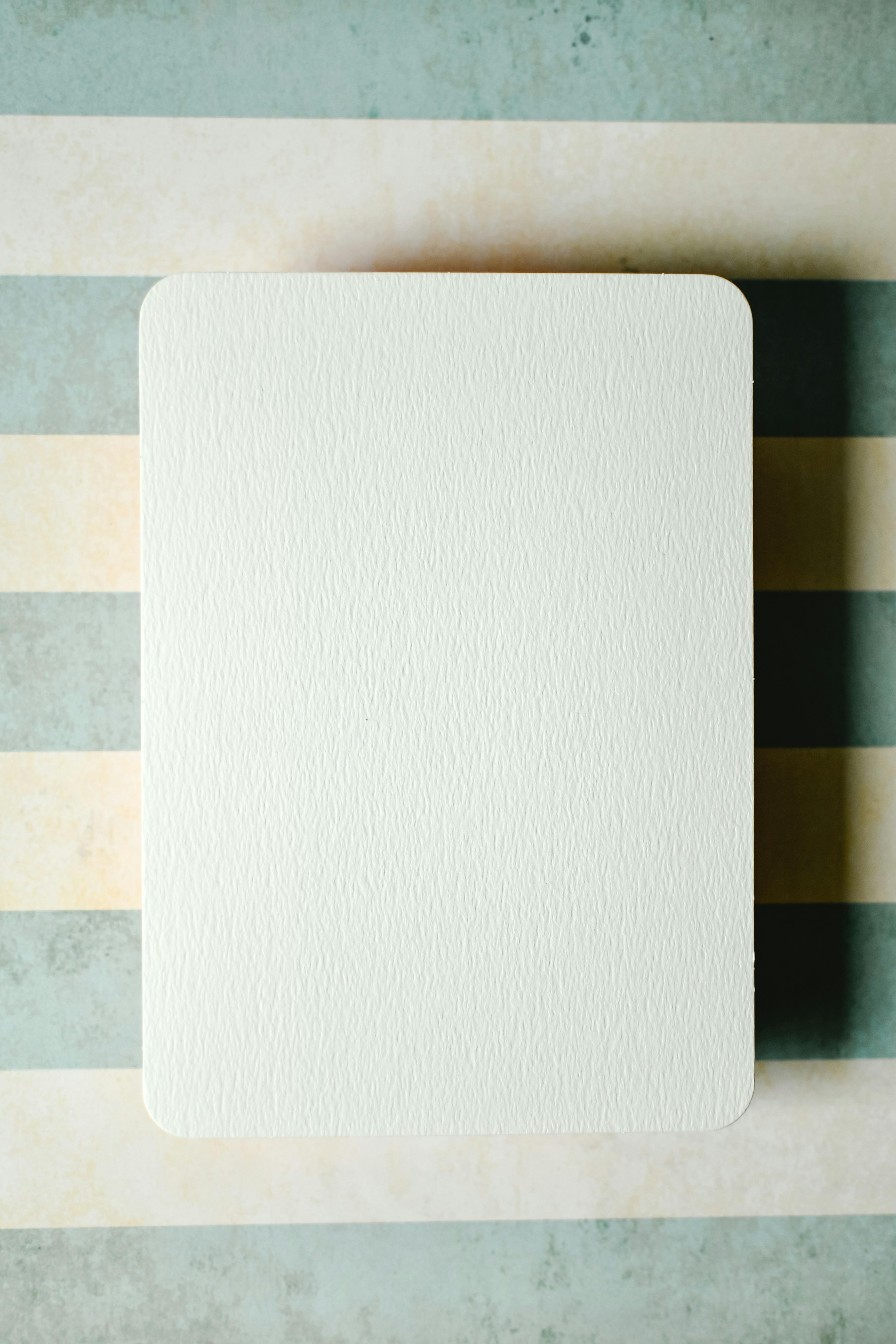 A blank card positioned on a striped surface, ideal for copyspace or text overlay in a creative project.