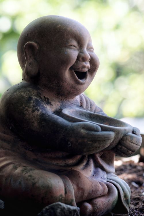 Free Close-up of a joyful Buddhist statue, symbolizing peace in a Vietnamese garden. Stock Photo