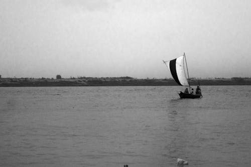 Grayscale Photograph of People on a Boat