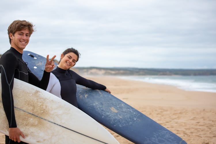 A Boy And A Girl With Their Surfboards