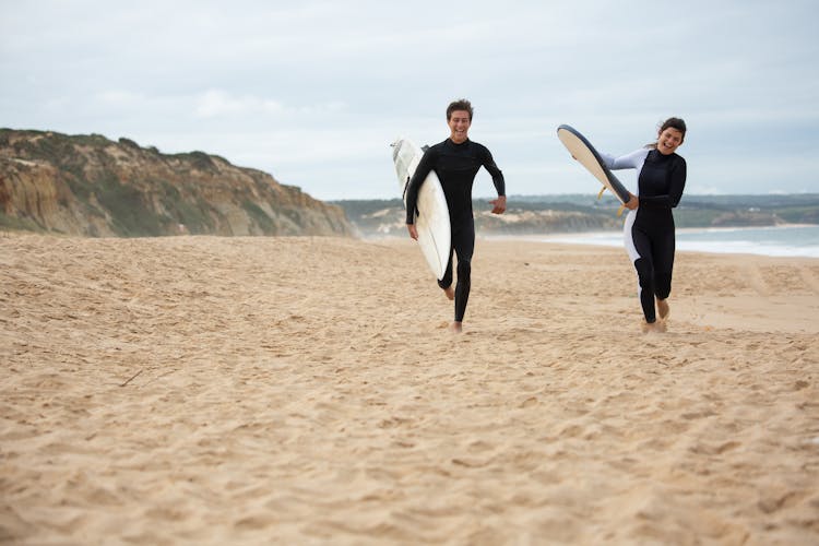 Surfers Running At The Beach