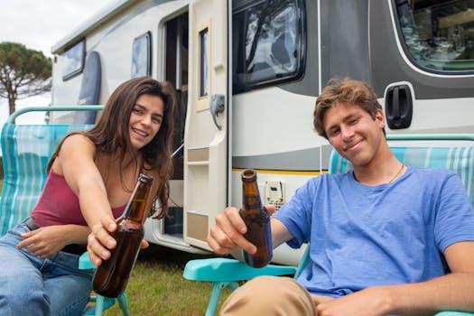 Young couple enjoys a summer vacation with beers at a camper van in Portugal.