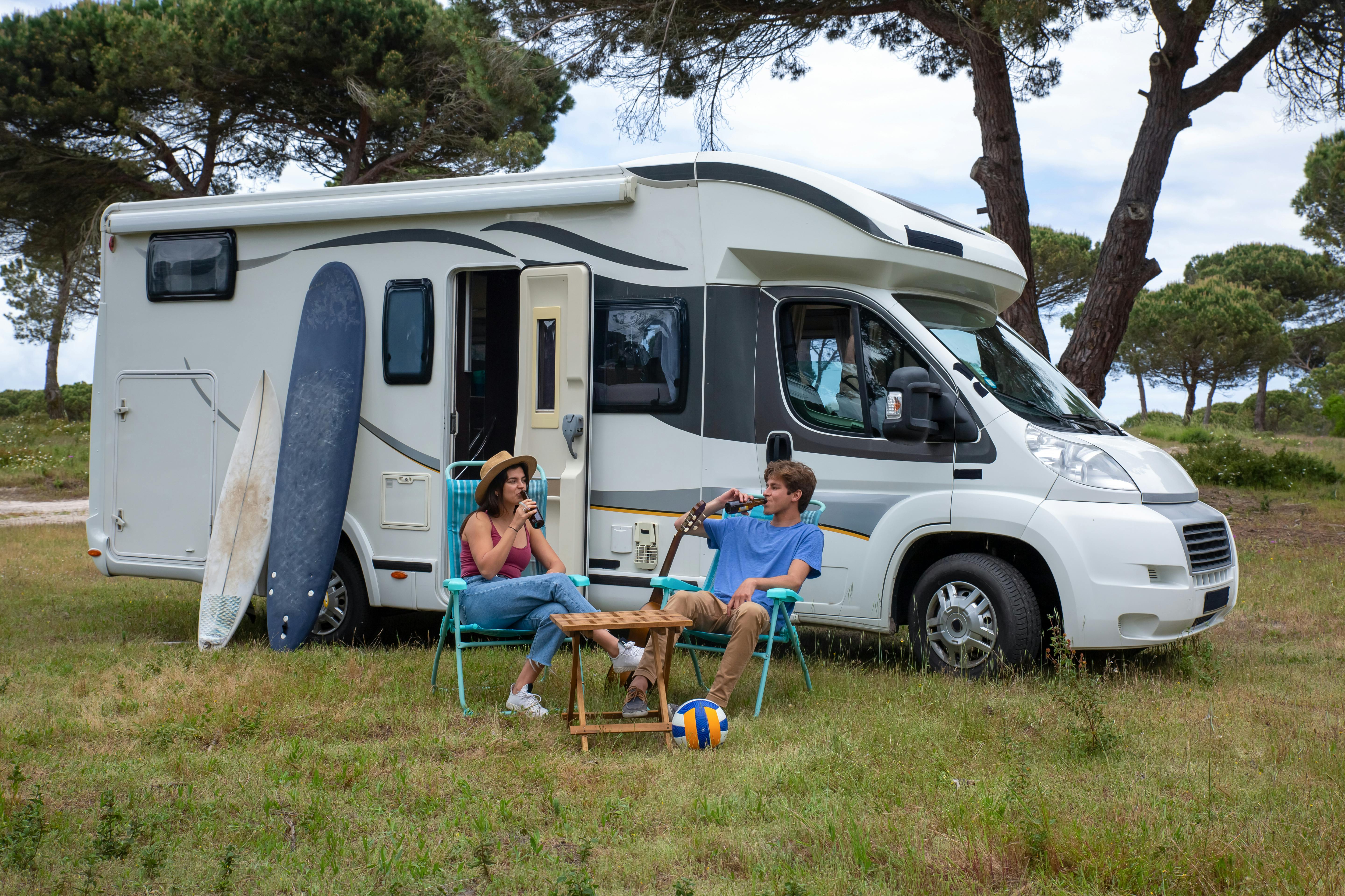 Enjoying leisure time with drinks by a camper van in Portugal's summer nature.