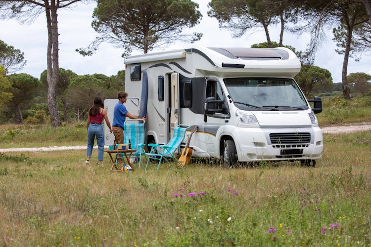 People Sitting On Blue And White Camper Trailer