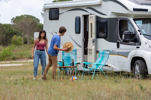 Free Man and Woman Standing Beside a Camper Stock Photo