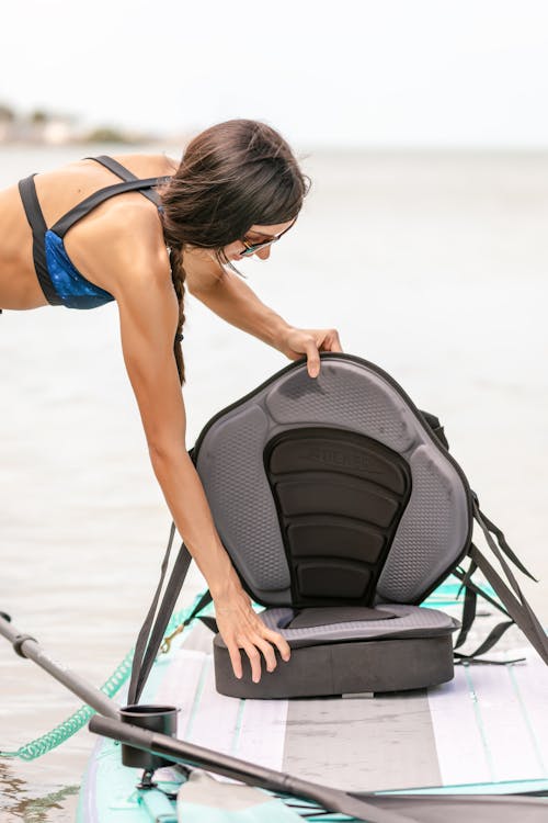 Free A Woman Unfolding a Chair in a Paddleboard Stock Photo