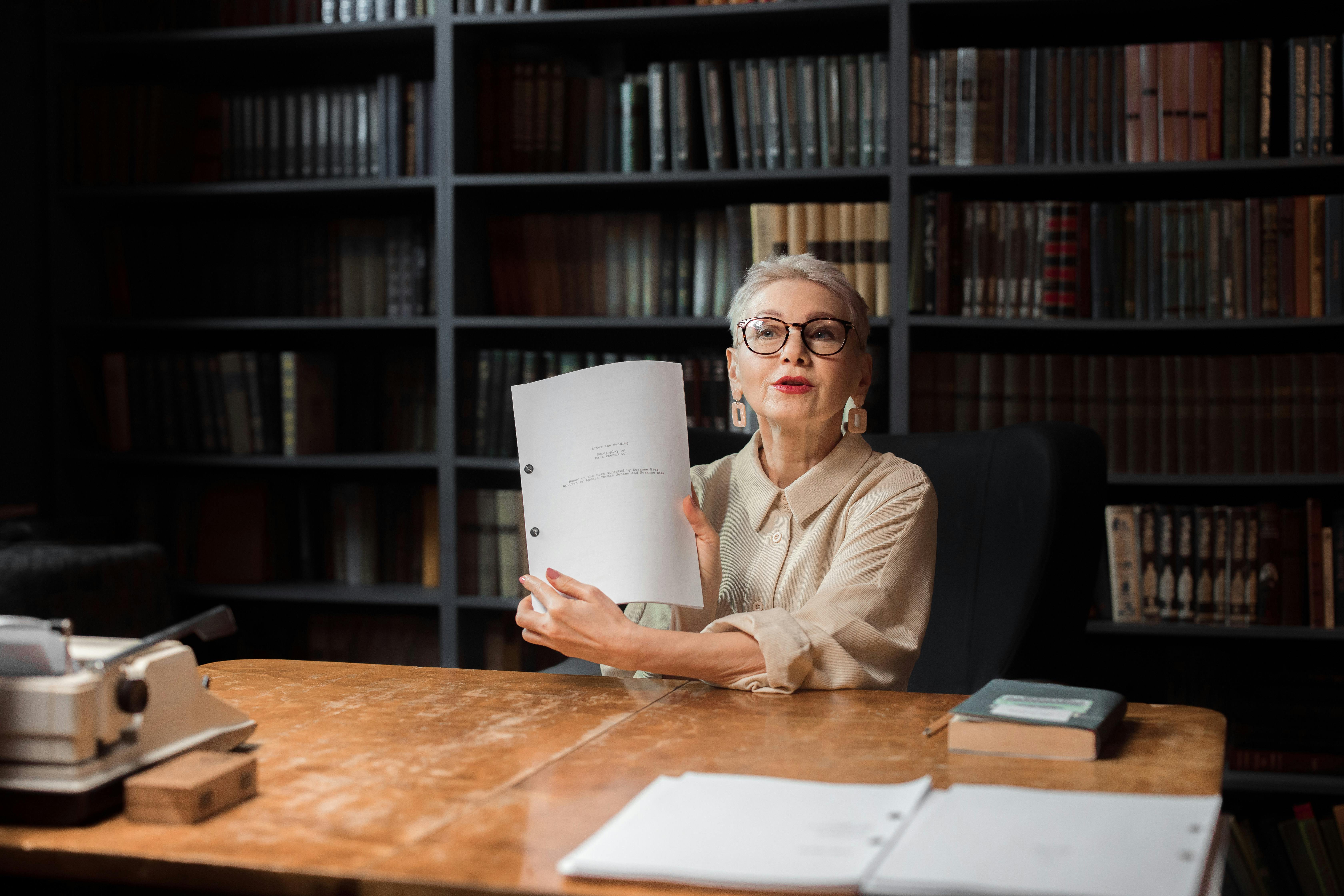 an elderly woman showing a manuscript