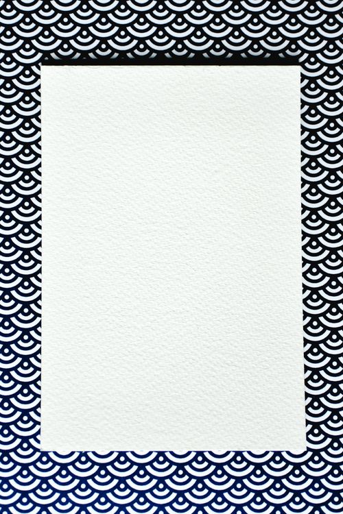 Free A blank textured sheet of paper against a stylish black and white patterned background, perfect for mockups. Stock Photo
