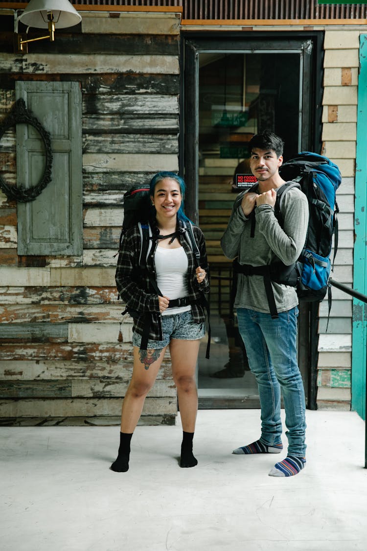 Diverse Couple Of Tourists Standing With Backpacks