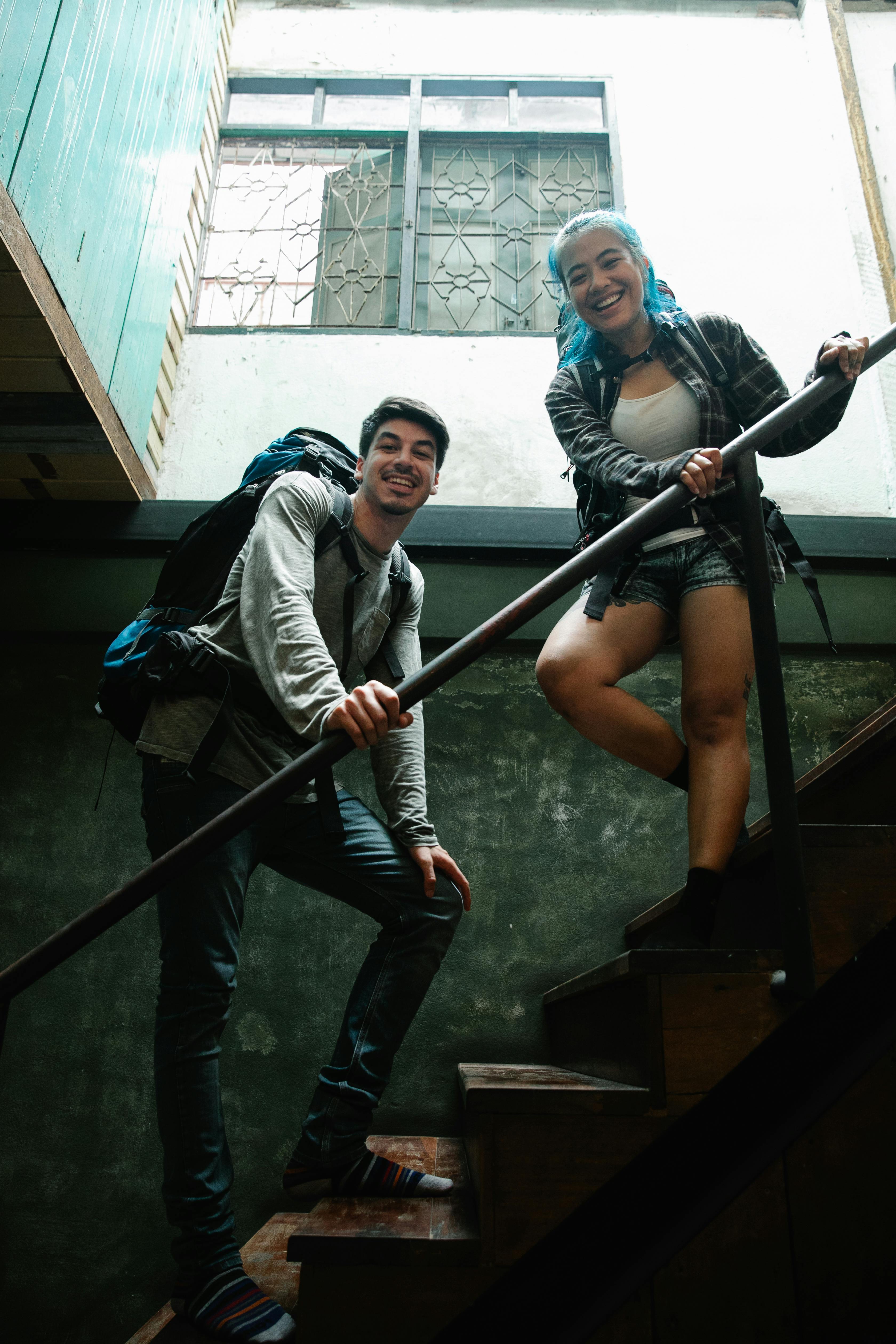 cheerful couple of travelers standing on stairs