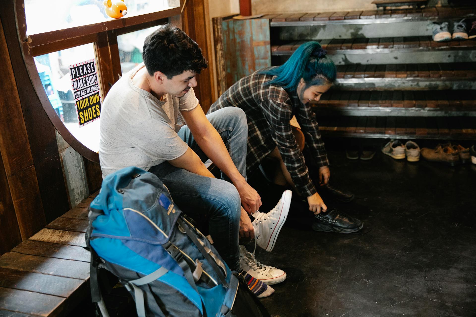 Young diverse couple of travellers taking off shoes