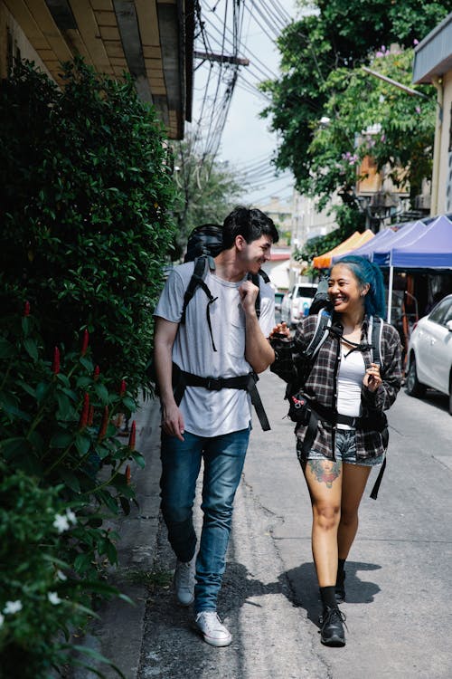 Young multiracial couple tourists walking on street