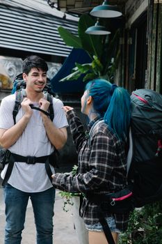 Two backpackers having a friendly conversation in an outdoor urban setting, ready for adventure.