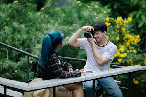 Young man taking photo of girlfriend in nature