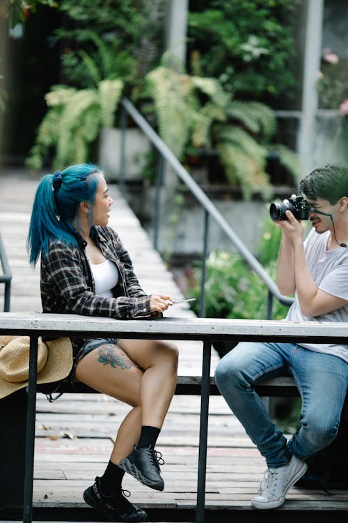 Man photographer taking photo on professional camera on footbridge