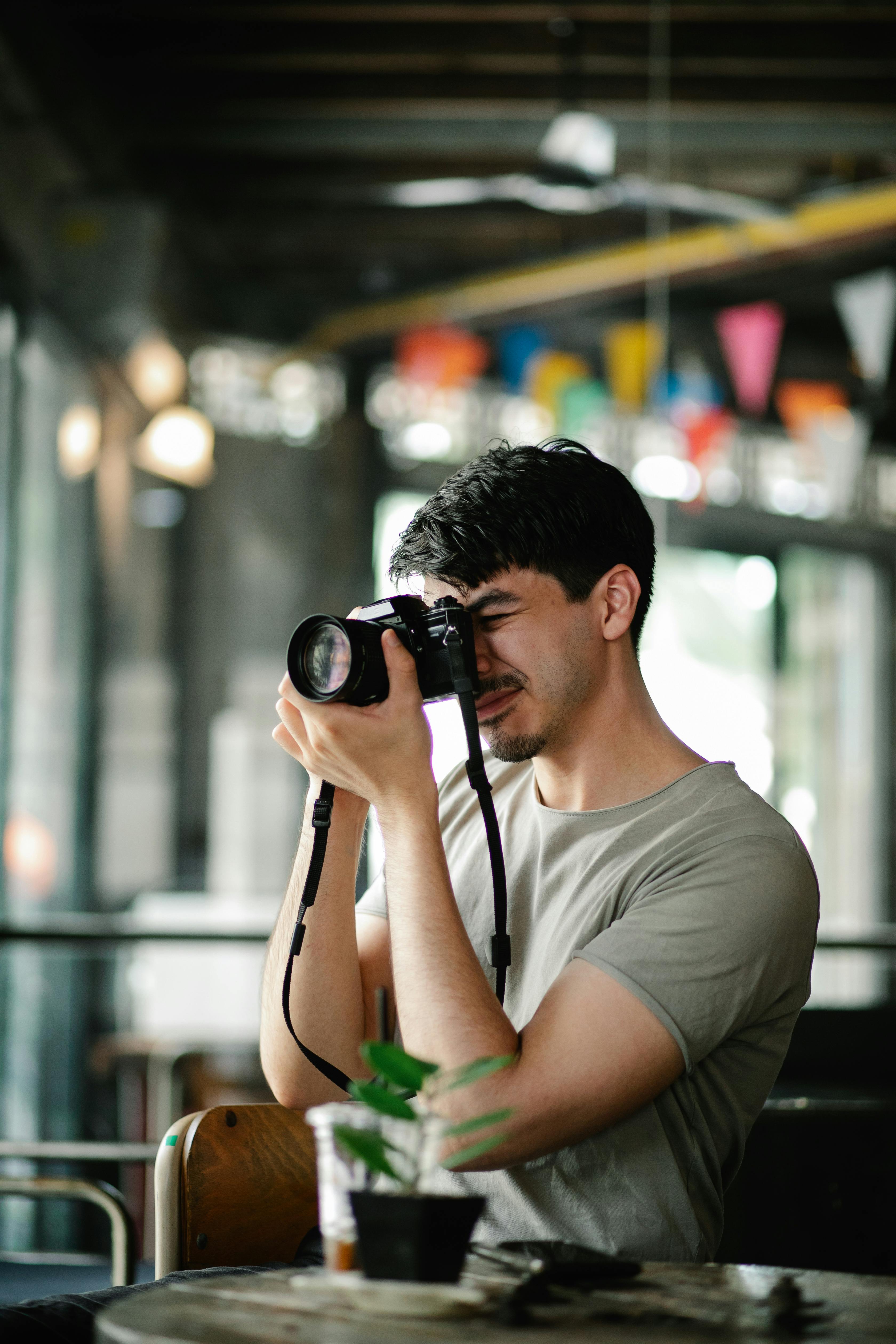 man taking photo at table in cafe