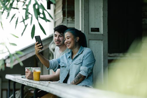 Content multiethnic couple taking selfie on terrace