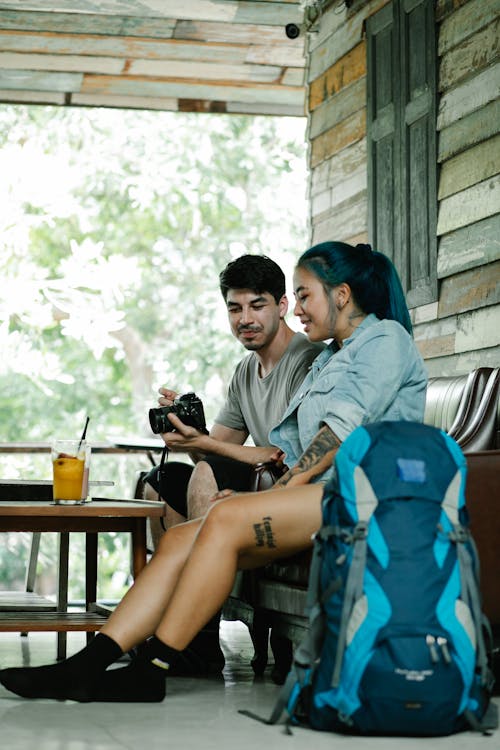 Free Positive diverse travelers with photo camera in cafe Stock Photo