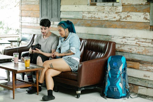 Man and Woman Sitting in a Cafe and Looking at Photos on a Camera 