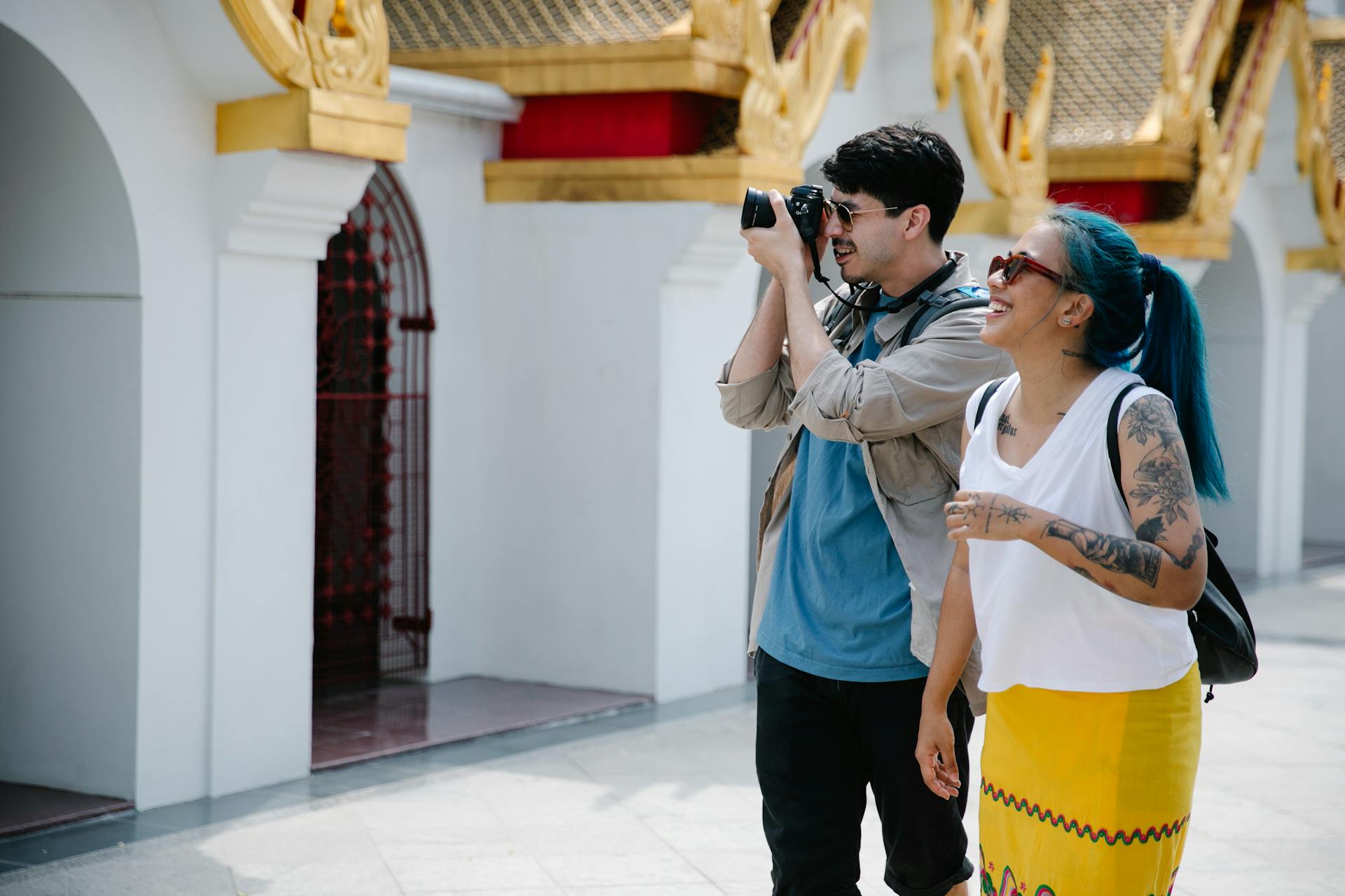 A couple enjoys sightseeing with a camera near beautiful architectural details. Outdoor adventure.