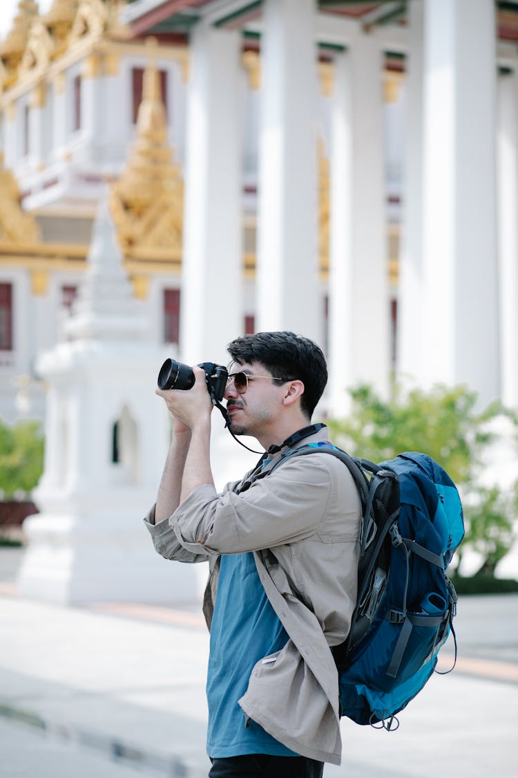 Man With Backpack Taking Picture With Camera