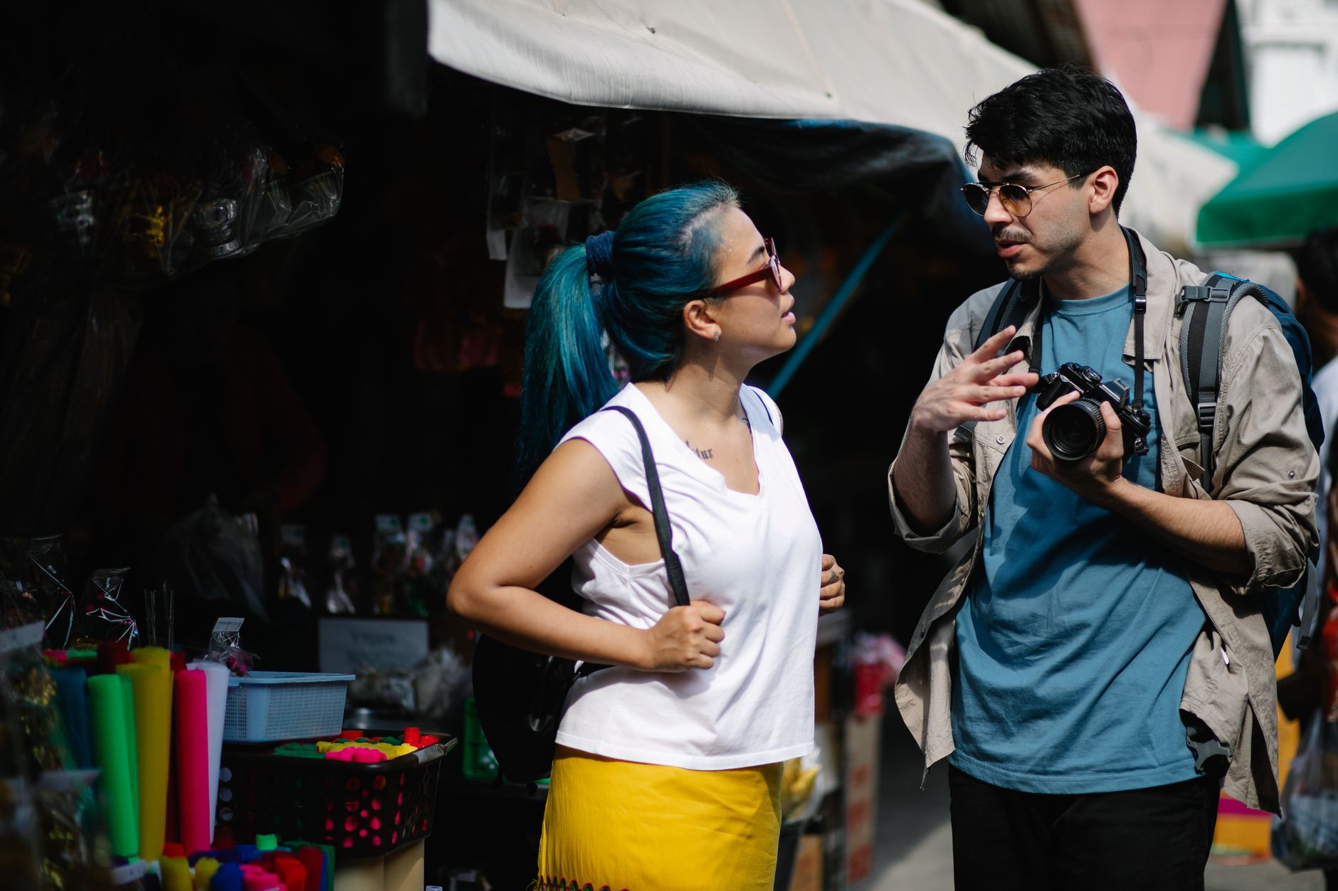 Travelers with a camera chatting in a bustling market