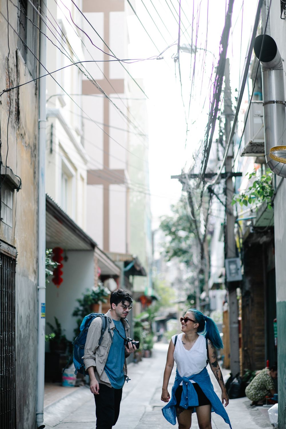 Two travellers with backpacks in a narrow street — photo by George Pak on Pexels