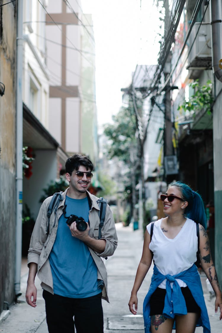 Couple With Backpacks Walking In City