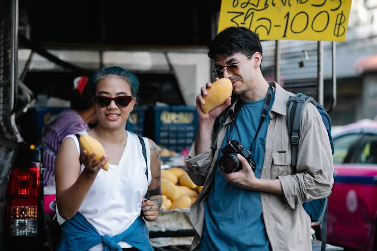 Man Smelling A Mango