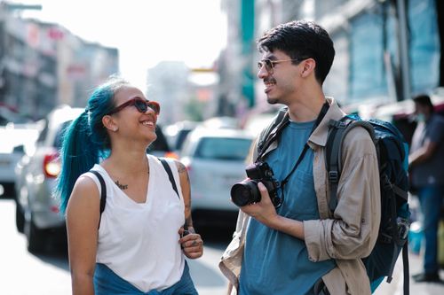 Free A cheerful couple enjoys a city exploration, capturing joyful moments in urban scenery. Stock Photo